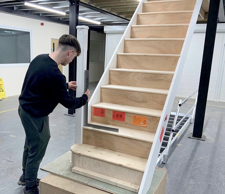 Trainee carpenter checking angles of staircase using a set square