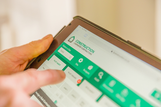 Close-up view of LJ Construction customer relationship management software on a tablet.